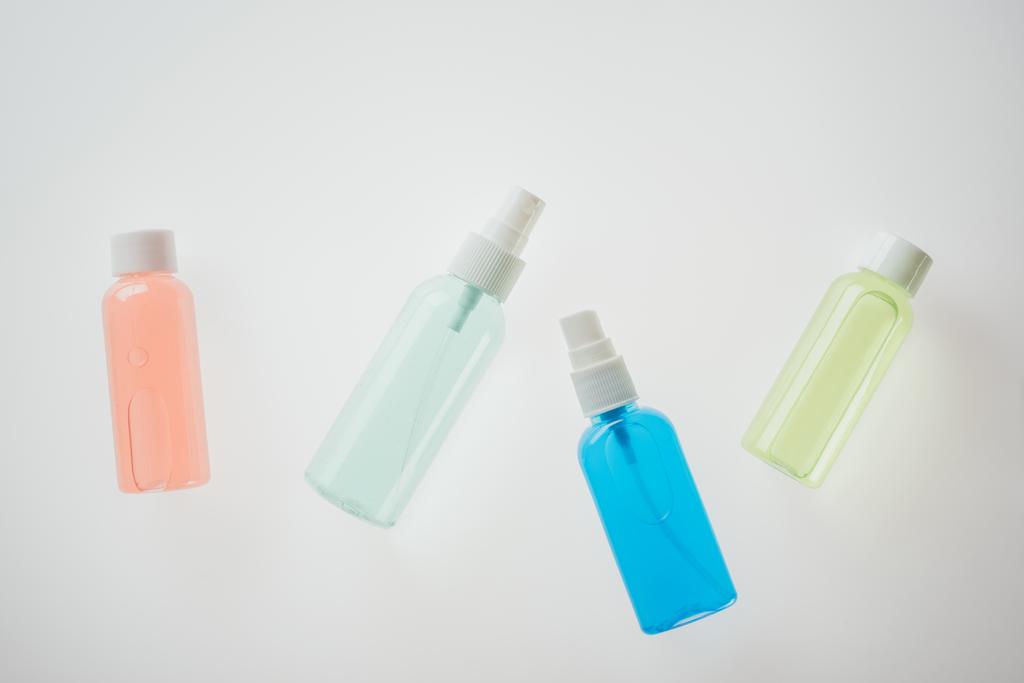 top view of colorful bottles with liquids on white background  - 写真・画像