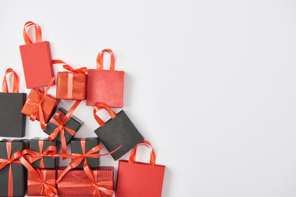 vista dall'alto di regali neri e rossi e shopping bag su sfondo bianco
 - Foto, immagini