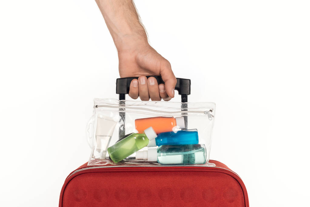 rajattu näkymä mies tilalla matkakassi Meikkilaukku värikkäitä pulloja nesteitä valkoisella pohjalla
  - Valokuva, kuva