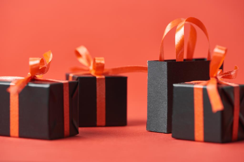 Nahaufnahme von Black-Friday-Geschenken und Einkaufstasche auf rotem Hintergrund - Foto, Bild