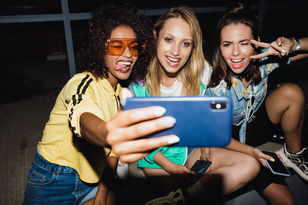Kız arkadaşlar geceleri sokakta selfie çekiyorlar.. - Fotoğraf, Görsel