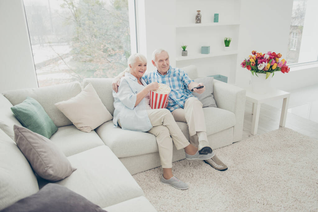 Two nice attractive cheerful cheery spouses having fun spending free time watching video serial comedian channel in light white interior living-room indoors - Photo, Image