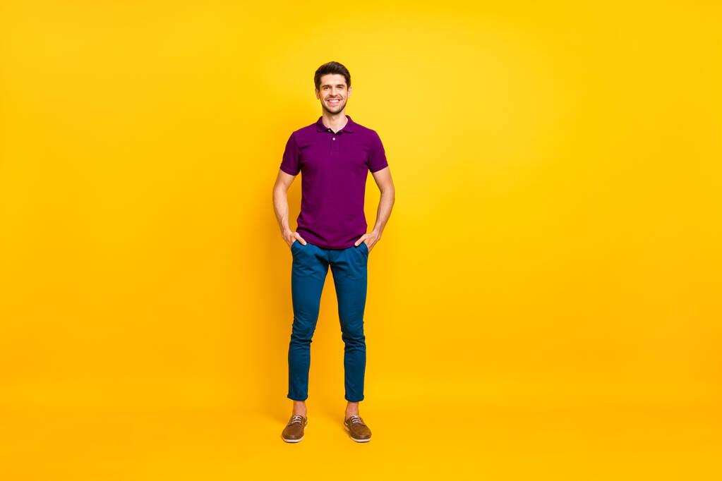 Plná délka tělo velikost fotografie veselý sebevědomý chytrý muž stojící s rukama v kapsách nosí kožené boty izolované přes živé barevné pozadí - Fotografie, Obrázek