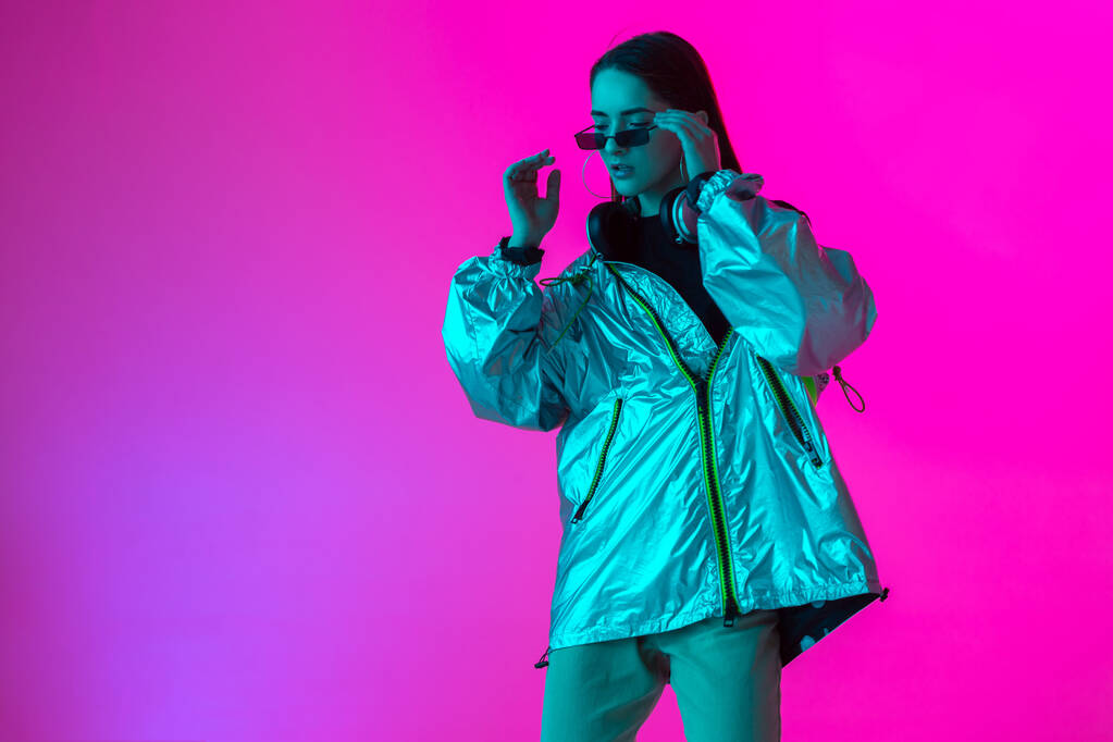 junge stilvolle Mädchen tanzen im Studio auf einem farbigen Neon-Hintergrund. Gestaltung von Musikplakaten. - Foto, Bild