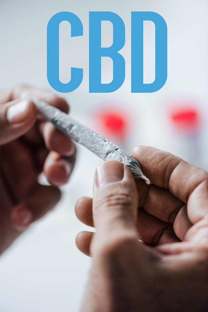 vue recadrée de l'homme tenant émoussé de cannabis médical avec le mot CBD
 - Photo, image