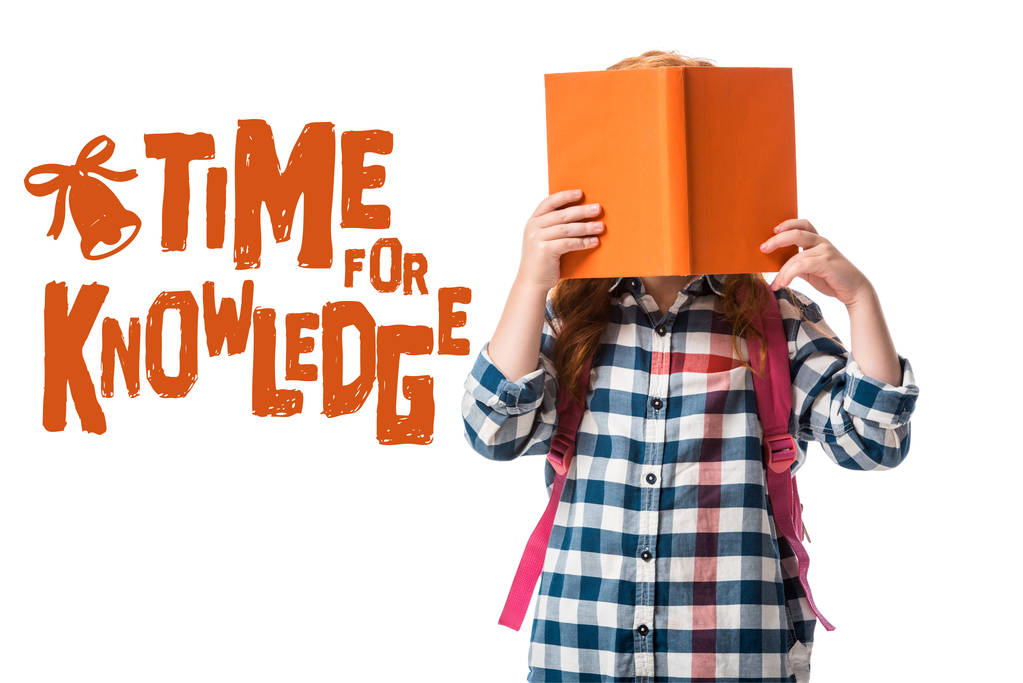 pupil covering face with orange book near time for knowledge letters on white  - Photo, Image