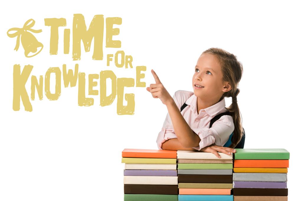 Pozitif okul çocuğu, beyazlar üzerine renkli kitapların yanındaki bilgi mektuplarını parmağıyla işaret ediyor.  - Fotoğraf, Görsel