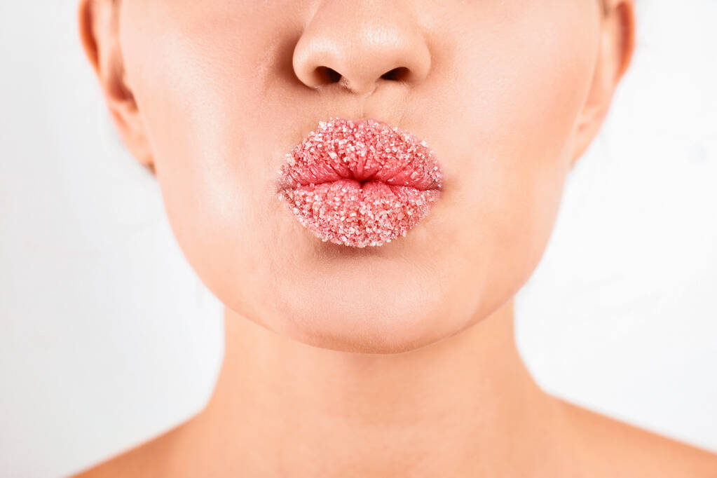 jonge vrouw met suiker lippen op witte achtergrond, close up - Foto, afbeelding