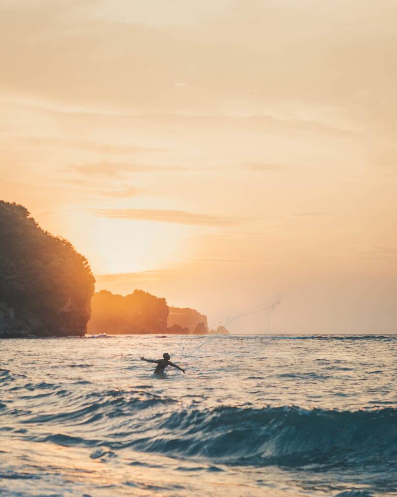 Pionowe ujęcie osoby bawiącej się w akwenach wodnych podczas pięknego zachodu słońca - Zdjęcie, obraz