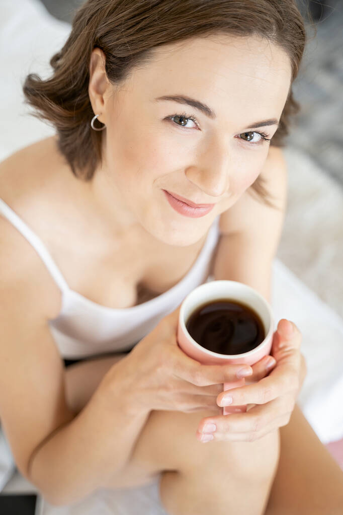 Χαρούμενη κυρία με ένα φλιτζάνι καφέ. - Φωτογραφία, εικόνα