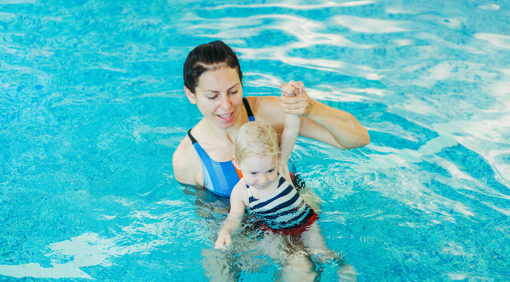 Piscina. Piscina. Mãe ensina uma criança a nadar na piscina
. - Foto, Imagem