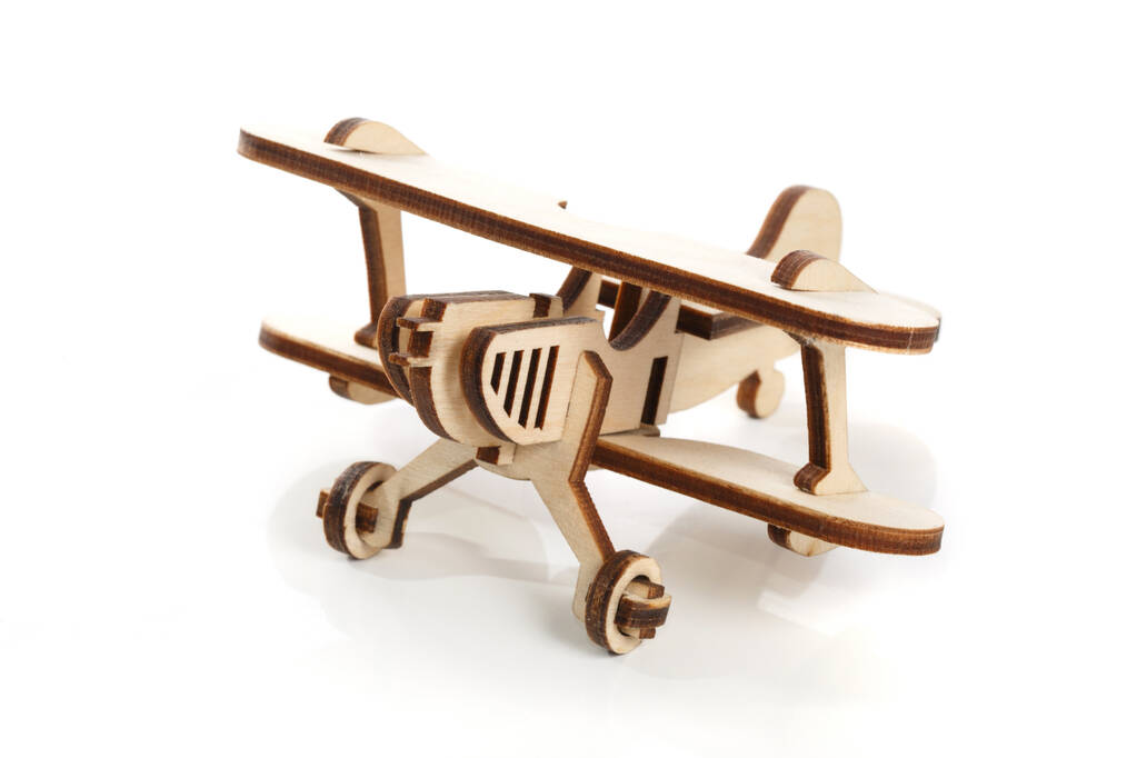 Modelo de juguete de madera de un avión de maíz excavado aislado sobre un fondo blanco
. - Foto, imagen