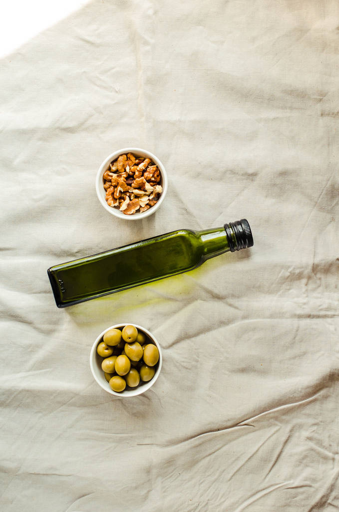 Olio extra vergine di noce in bottiglia di vetro verde e olive verdi
 - Foto, immagini