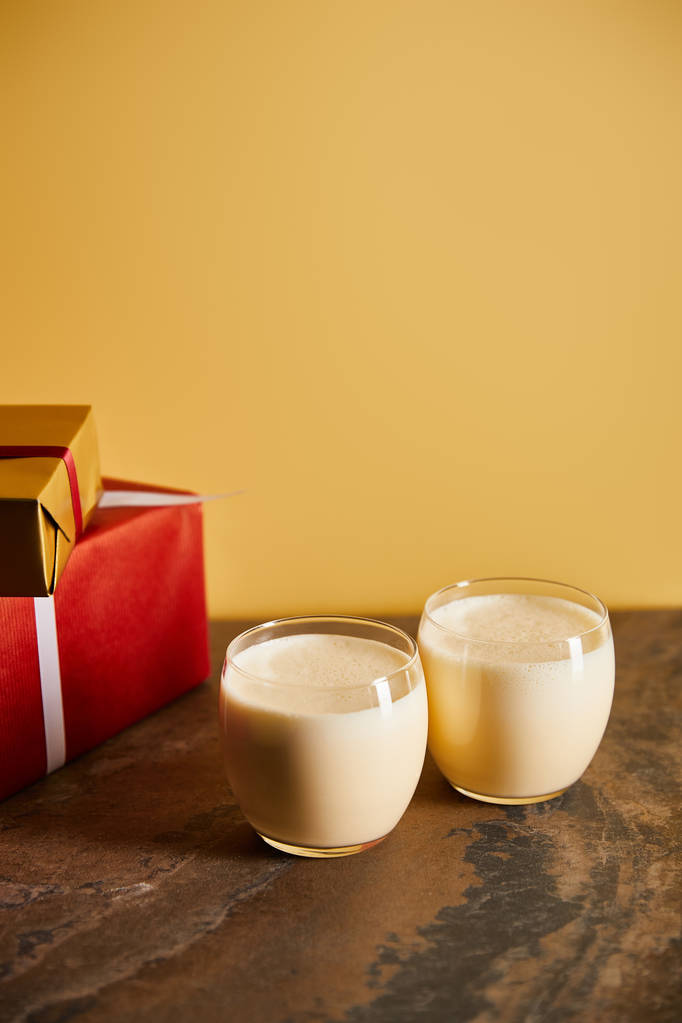 délicieux cocktail au lait de poule et boîtes-cadeaux sur table en marbre foncé isolé sur orange
 - Photo, image