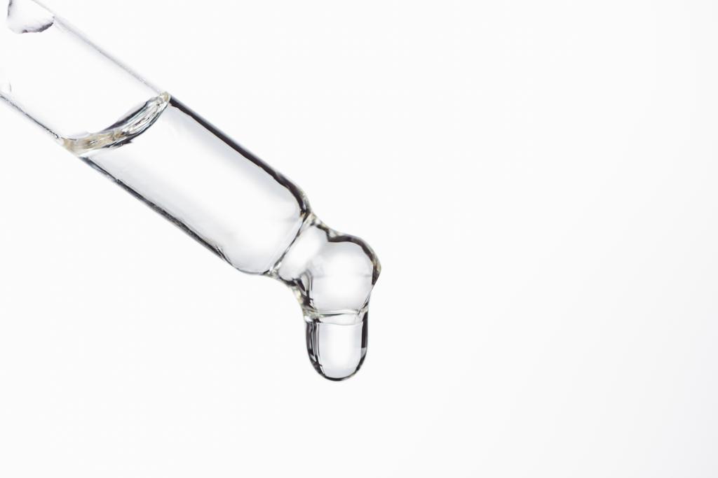 pipetowane naturalnym serum z kroplą wyizolowaną na biało - Zdjęcie, obraz