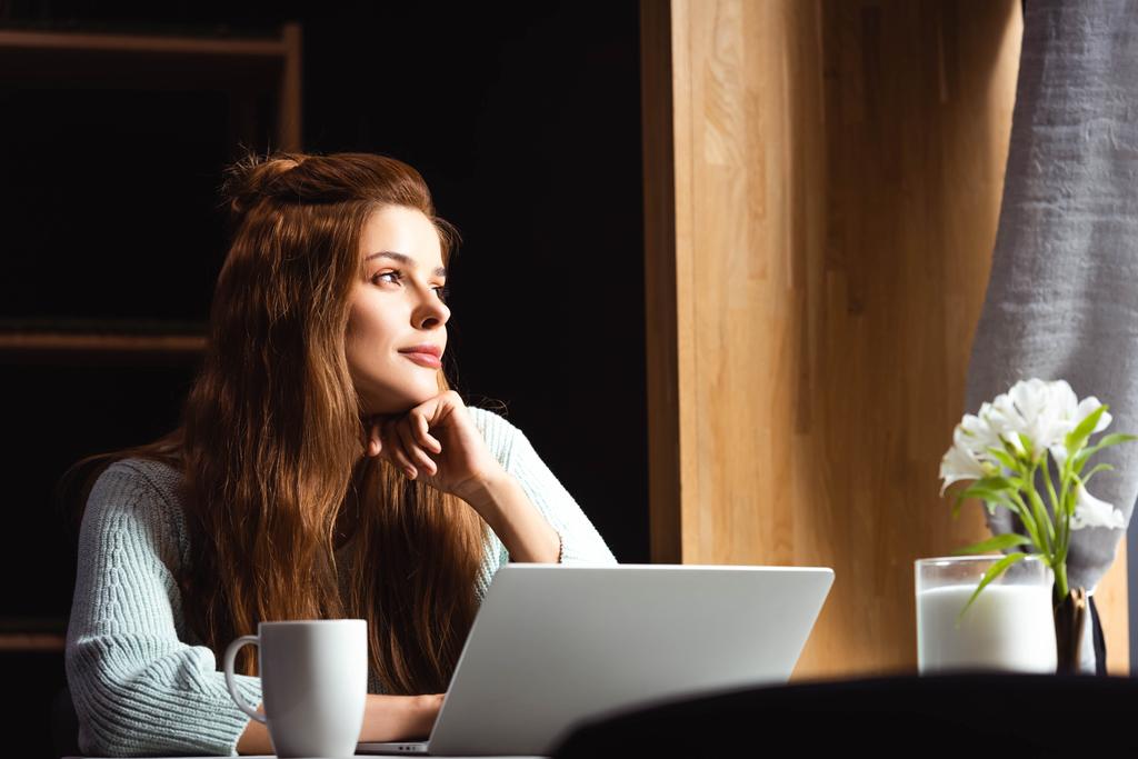 donna rossa sognante utilizzando il computer portatile in caffè con tazza di caffè
 - Foto, immagini