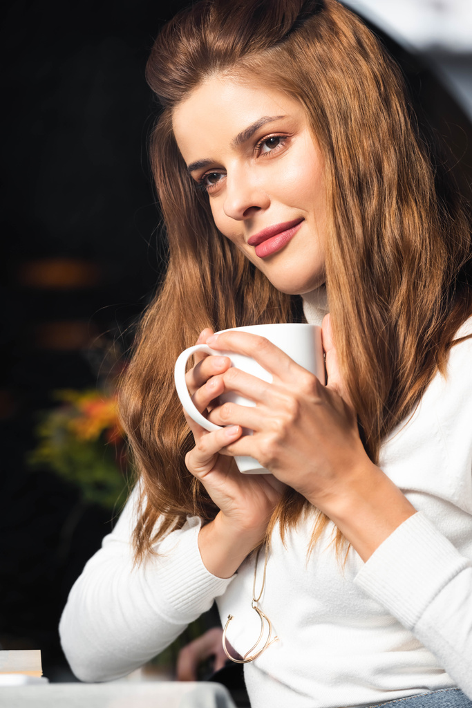 gyönyörű álmodozó nő kezében egy csésze kávét kávézóban  - Fotó, kép