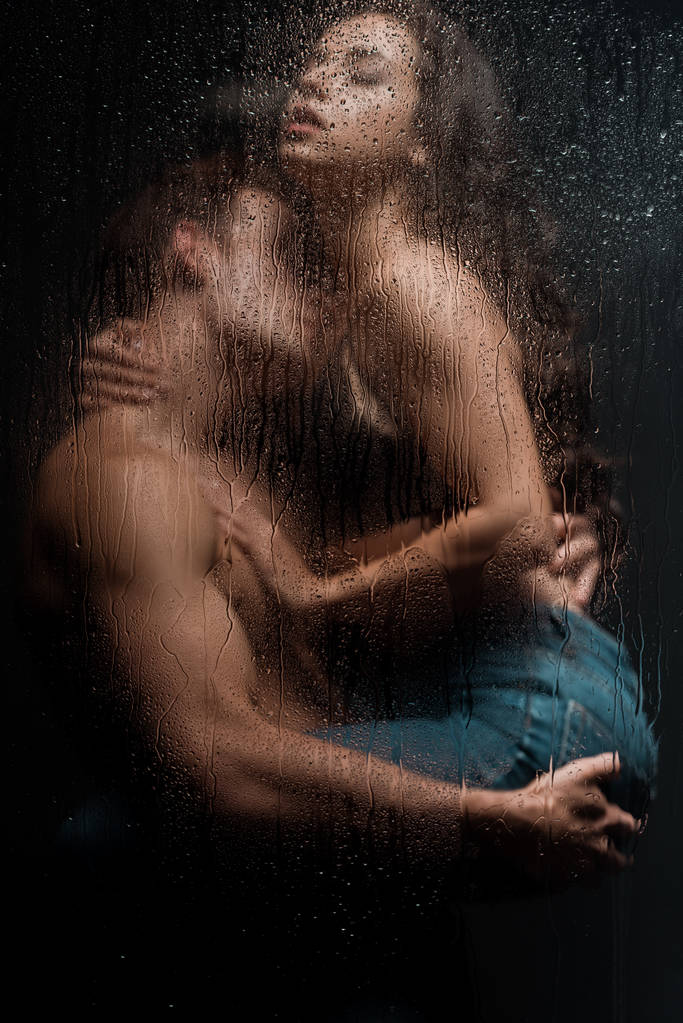 bella coppia appassionata che si abbraccia dietro vetro bagnato
 - Foto, immagini