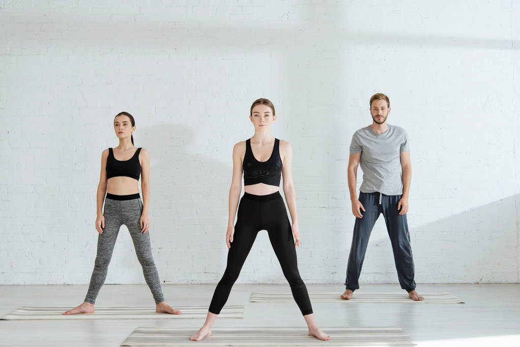 young men and woman practicing yoga in star pose - Photo, Image