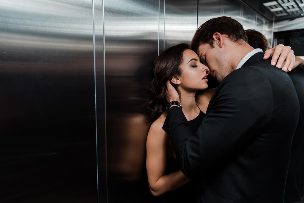 όμορφο παθιασμένο ζευγάρι αγκαλιάζει και πρόκειται να φιλήσει στο ασανσέρ - Φωτογραφία, εικόνα