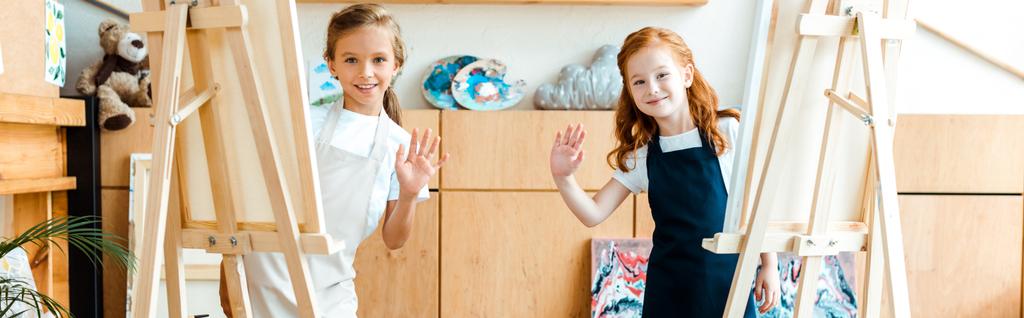 plano panorámico de niños felices saludando las manos en la escuela de arte
  - Foto, Imagen