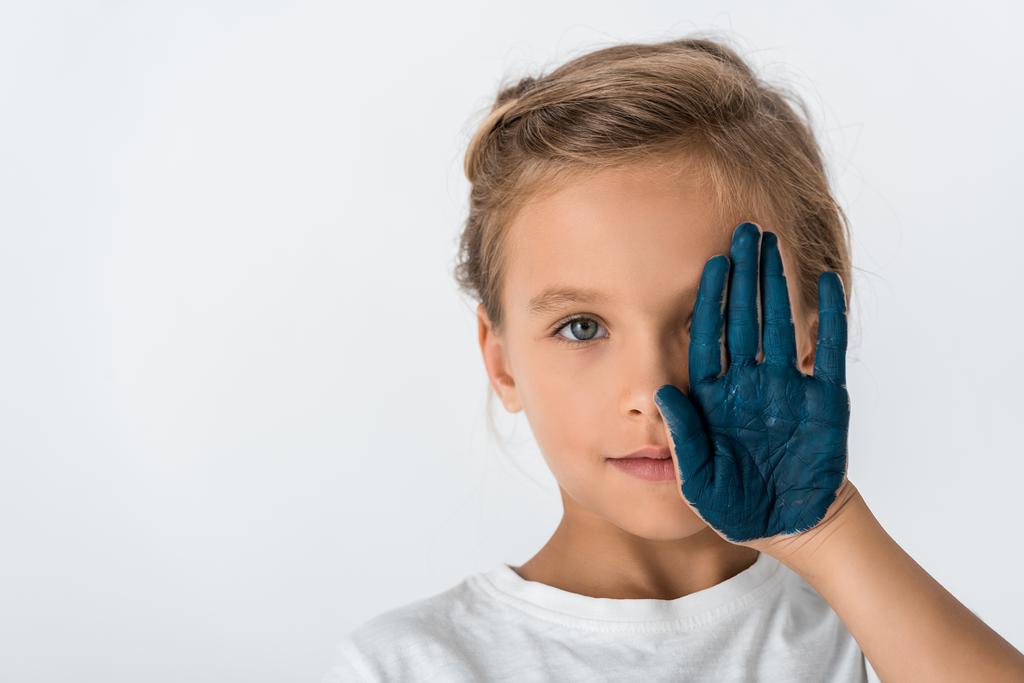 criança com tinta azul na mão cobrindo rosto isolado no branco
  - Foto, Imagem