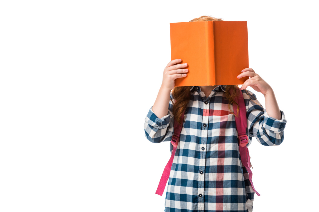 κόρη που καλύπτει το πρόσωπο με πορτοκαλί βιβλίο απομονώνονται σε λευκό  - Φωτογραφία, εικόνα