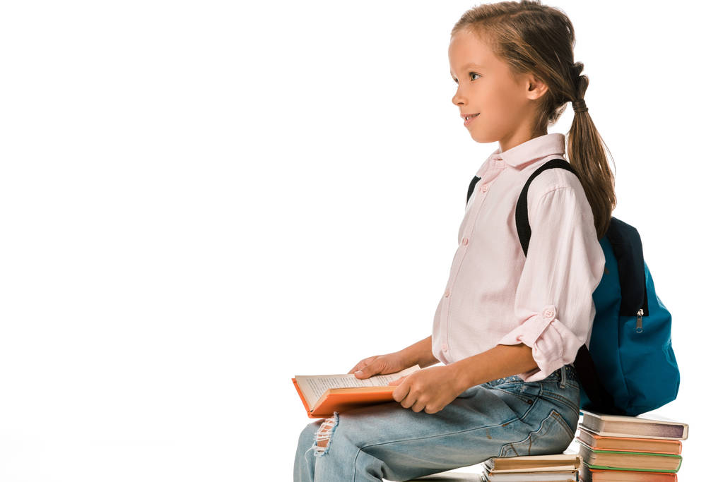 веселий школяр сидить на книгах ізольовано на білому
  - Фото, зображення