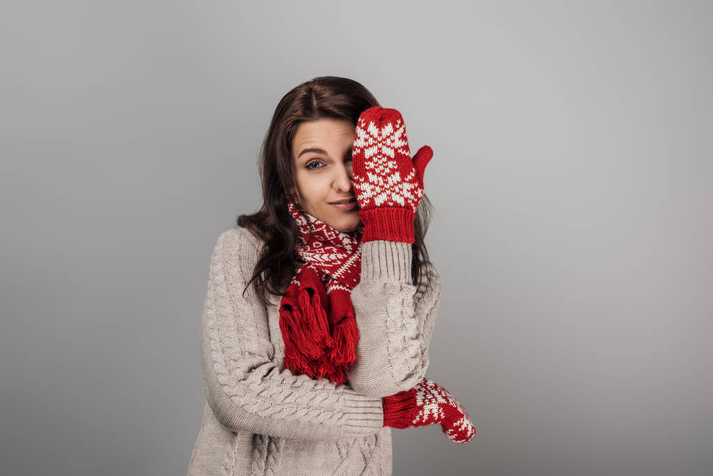 ελκυστική γυναίκα με κόκκινα γάντια και μαντήλι που καλύπτει το μάτι απομονώνονται σε γκρι  - Φωτογραφία, εικόνα