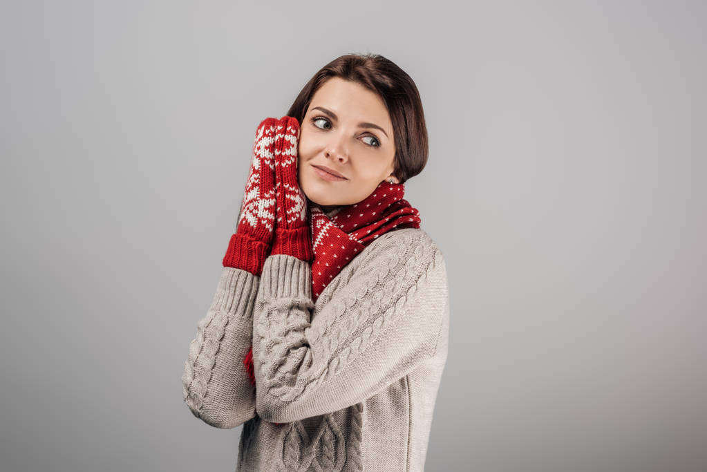 dromerige vrouw in rode handschoenen en sjaal geïsoleerd op grijs  - Foto, afbeelding