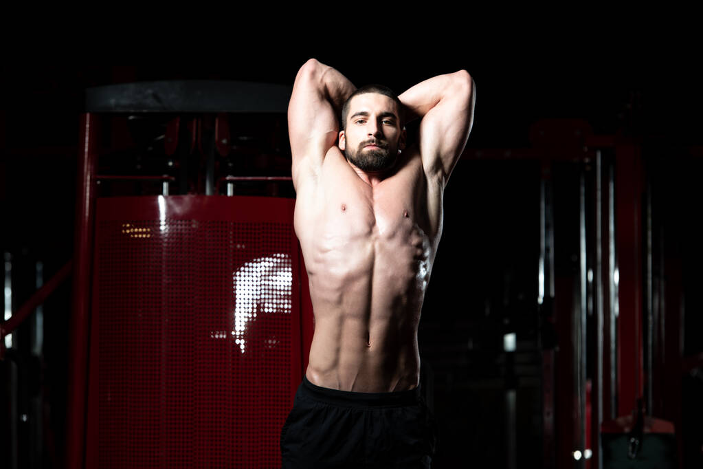 Человек в спортзале показывает свое хорошо подготовленное тело
 - Фото, изображение