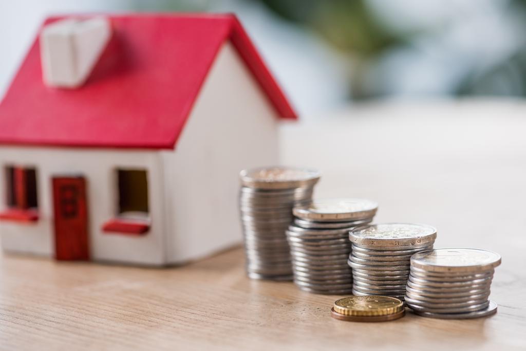 вибірковий фокус запас срібних і золотих монет біля іграшкового будинку на дерев'яному столі
 - Фото, зображення