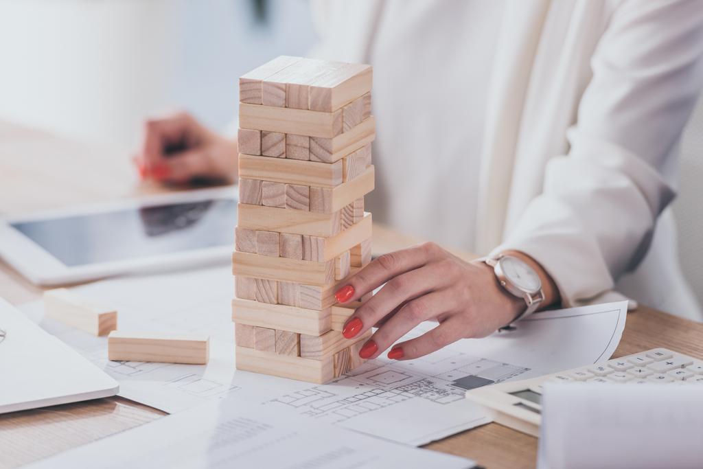cropped view of businesswoman touching stack of wooden blocks - Photo, Image