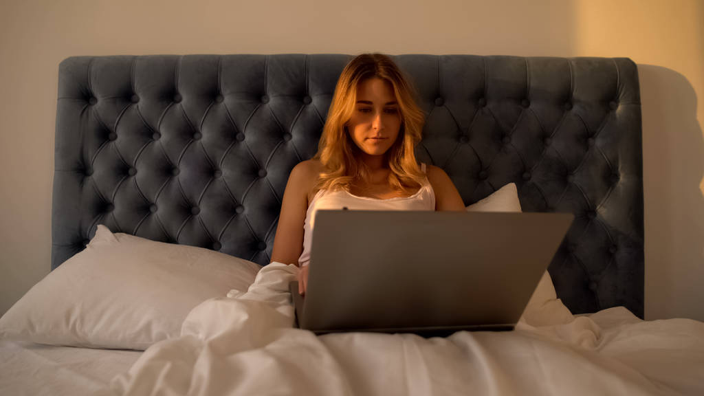 Müde Frau, die bis zum Morgen am Laptop im Bett arbeitet, überlastete Freiberuflerin - Foto, Bild