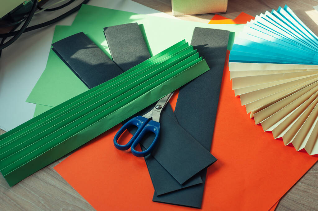 Оригами красочные вентиляторы, листы бумаги, ножницы на деревянном столе. Несколько холостых для вентилятора. Шаблон для дизайна, рекламы или текста
. - Фото, изображение