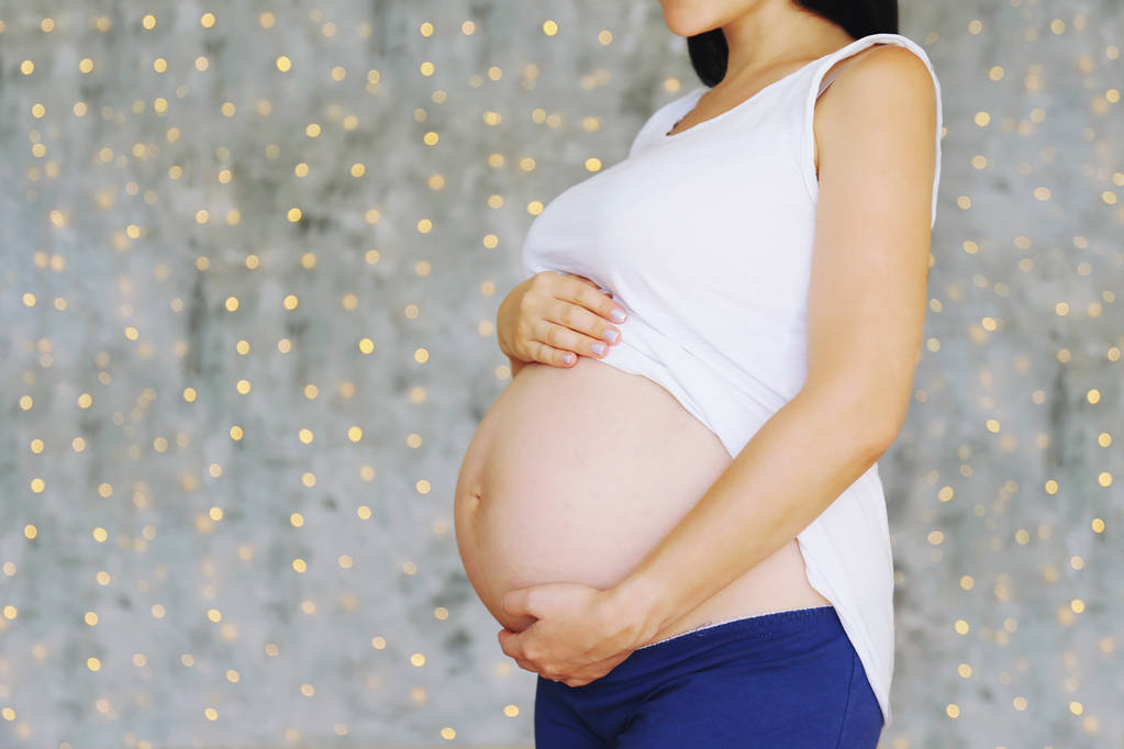 Giovane donna che tiene la pancia incinta il nono mese di gravidanza
. - Foto, immagini
