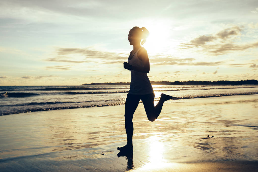 Fitness-Frau läuft am Strand von Sonnenuntergang - Foto, Bild