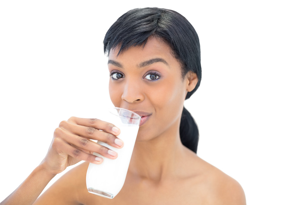 Зачарована чорна волохата жінка п'є склянку молока
 - Фото, зображення