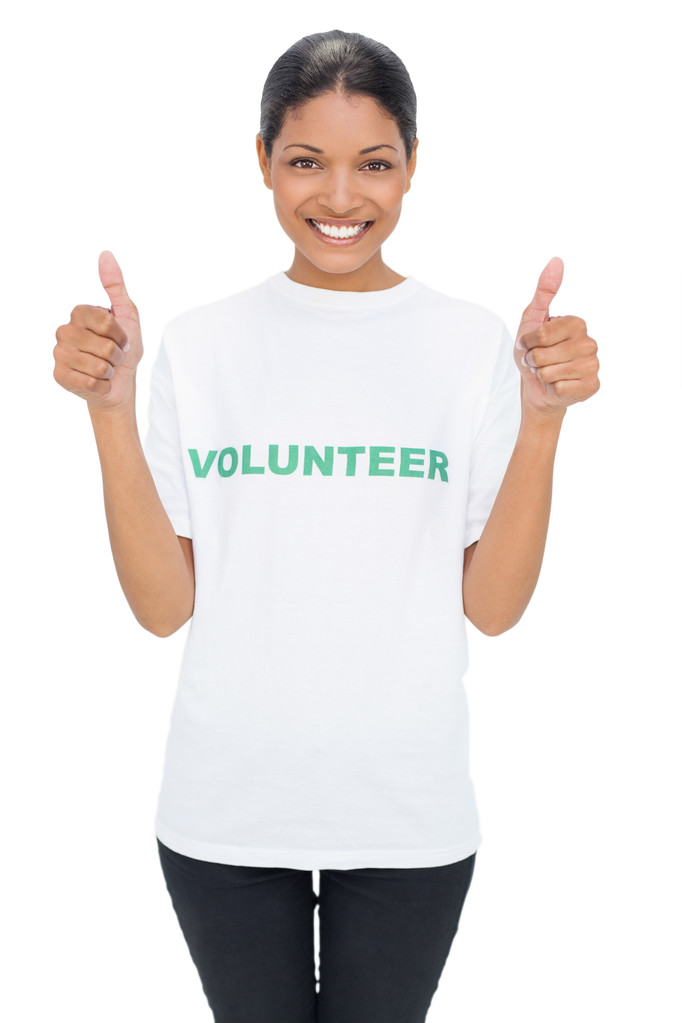 Усміхнена модель одягнена у волонтерську майку, що дає великі пальці вгору
 - Фото, зображення