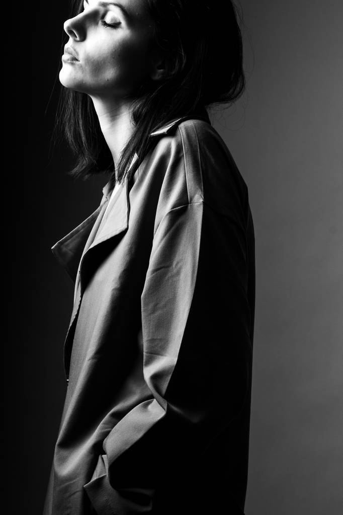 schönes junges Mädchen im Trenchcoat, schwarz-weiß  - Foto, Bild