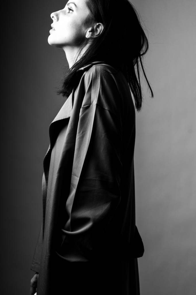 hermosa joven en un abrigo de trinchera, blanco y negro
  - Foto, Imagen
