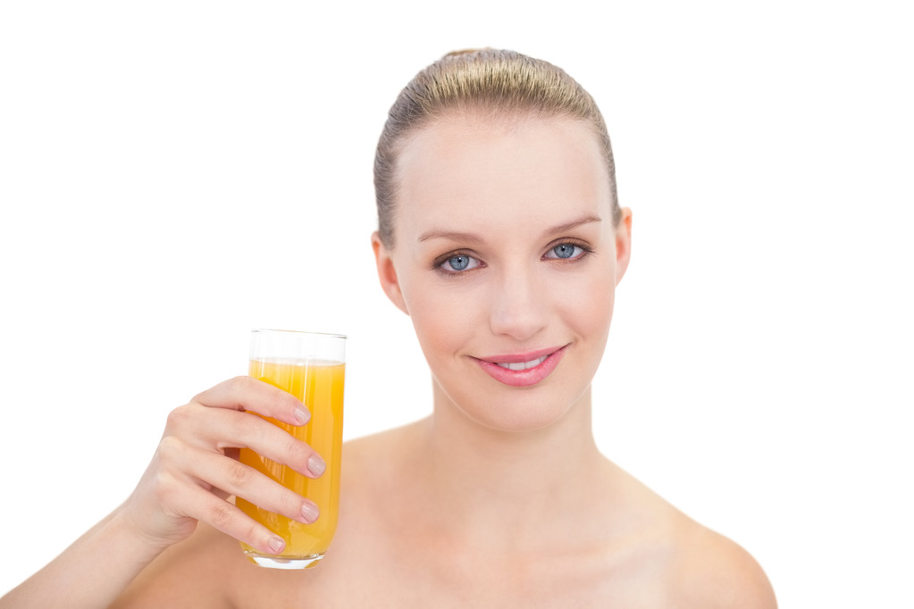 Alegre modelo rubia bonita sosteniendo un vaso de jugo de naranja
 - Foto, Imagen