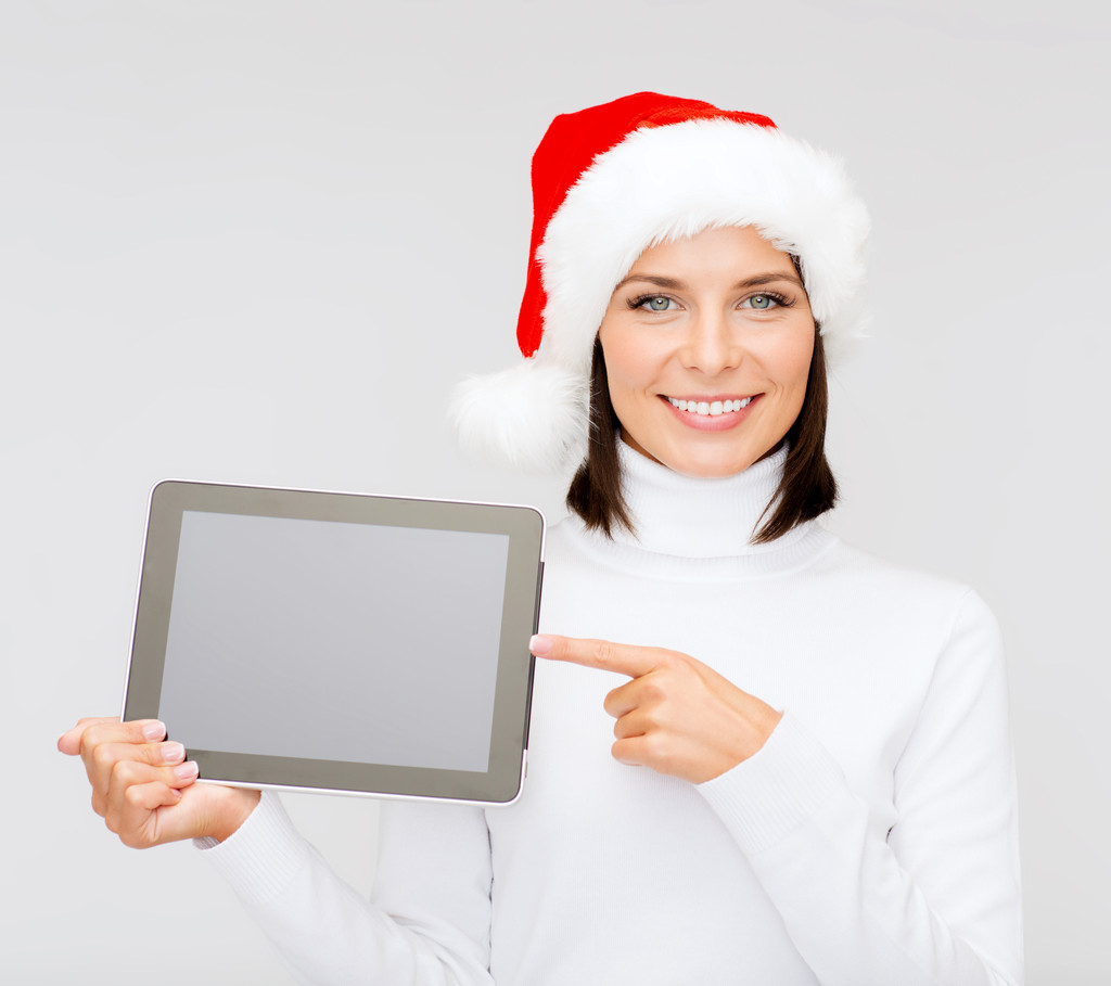 vrouw in helper kerstmuts met tablet pc - Foto, afbeelding
