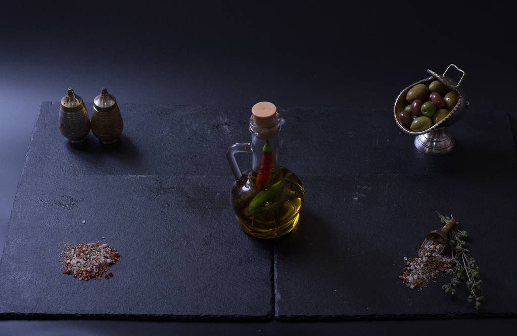 una jarra de mantequilla junto a verduras y especias sobre un fondo oscuro
 - Foto, Imagen