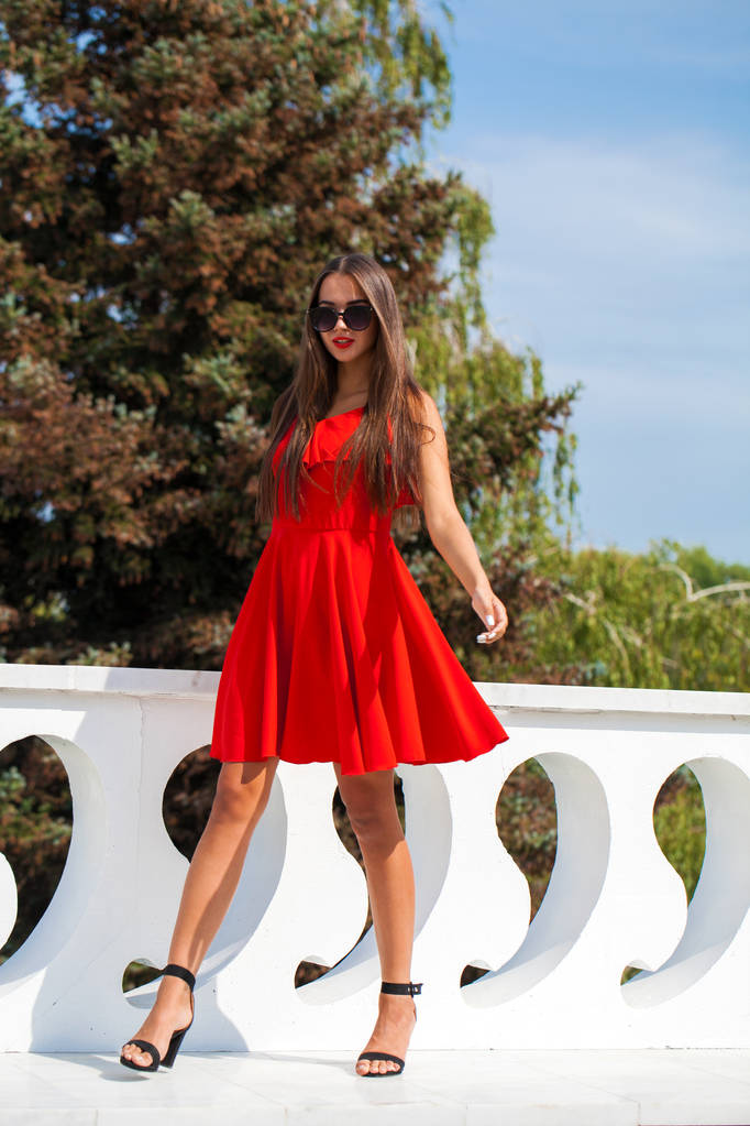 Nuori kaunis nainen punaisessa mekossa kesäkadulla
 - Valokuva, kuva
