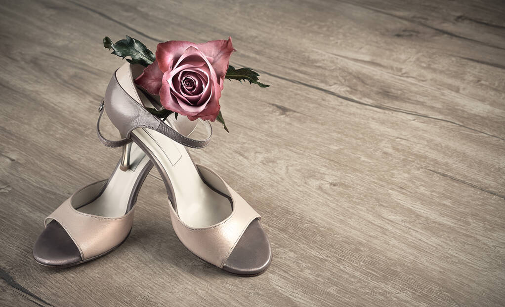 Sapatos de tango argentinos e uma rosa em um chão de madeira, espaço
 - Foto, Imagem