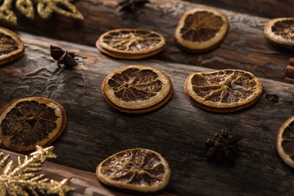 fatias de citrinos secos com anis e flocos de neve decorativos em fundo de madeira
 - Foto, Imagem