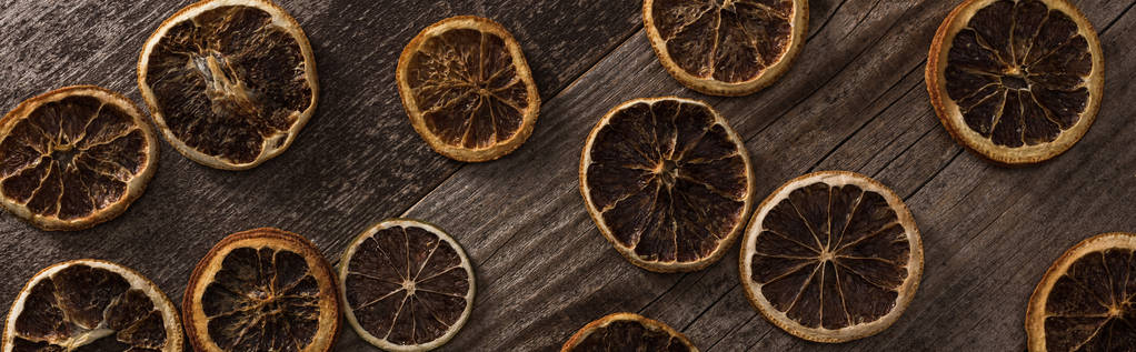 top view of dried citrus slices on wooden brown surface, panoramic shot - 写真・画像