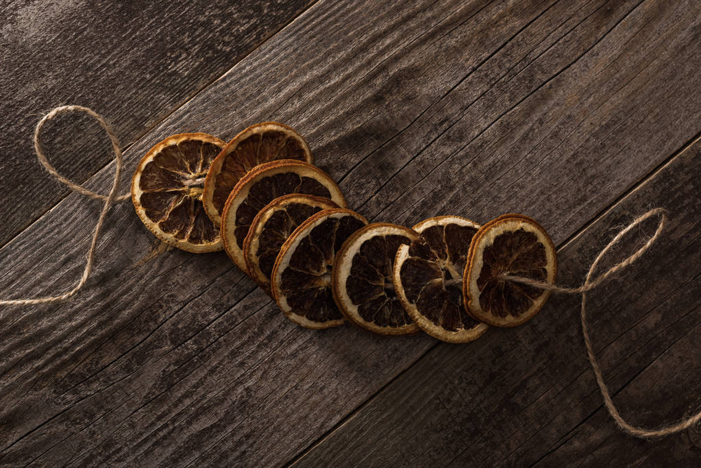 ylhäältä näkymä kuivattuja appelsiinin viipaleita köyden puupinnalla
 - Valokuva, kuva