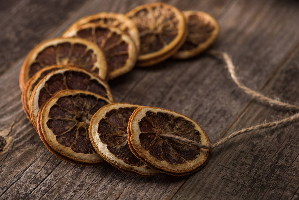sušené pomerančové plátky na niti na dřevěném stole - Fotografie, Obrázek